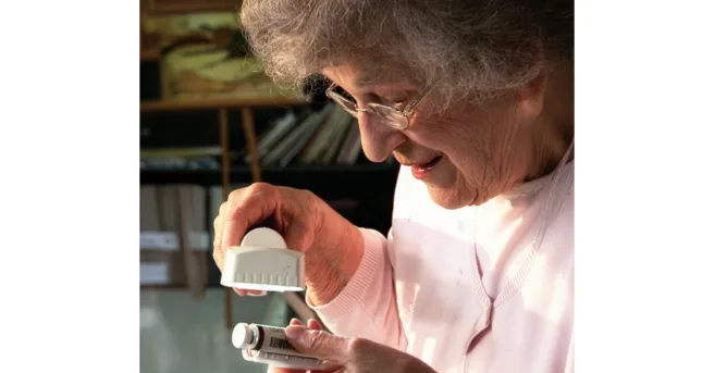 woman look at pill bottle through a magnifier
