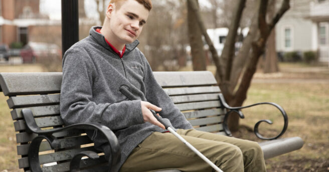 A young man sitting on a park bench