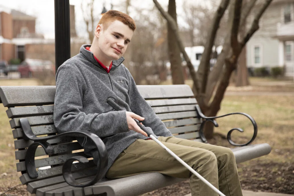 A young man sitting on a park bench