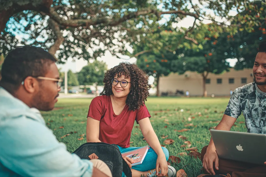college students sitting on the ground talking