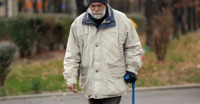  Older person walking with a support cane