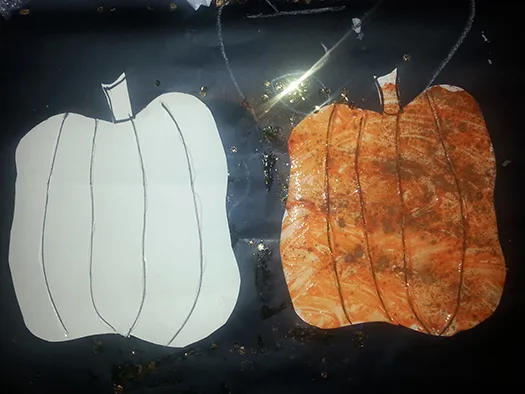 a before-and-after picture of a pumpkin cutout, decorated with finger paint and spices
