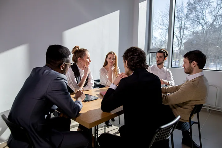 A diverse group of teachers having a discussion in a conference room.