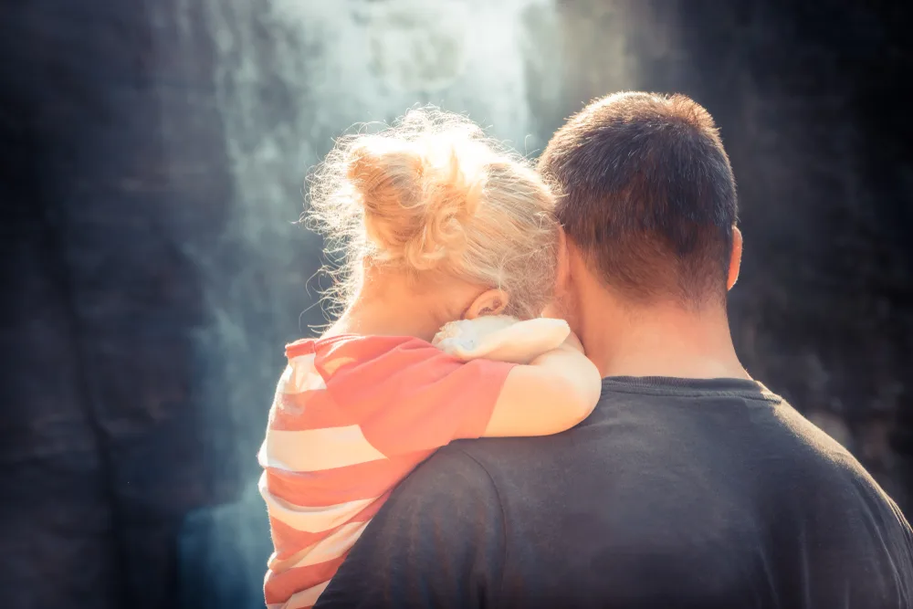 Father embracing daughter.