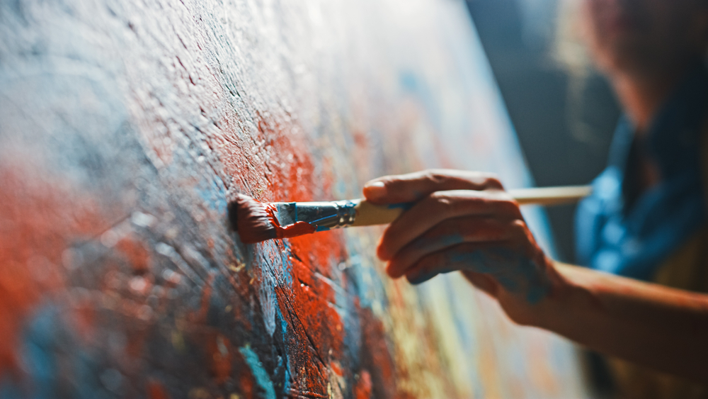 Close-up of person painting a vibrant, abstract painting