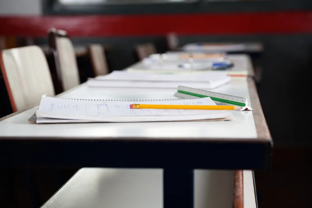 Books and pencils on desk in classroom. 