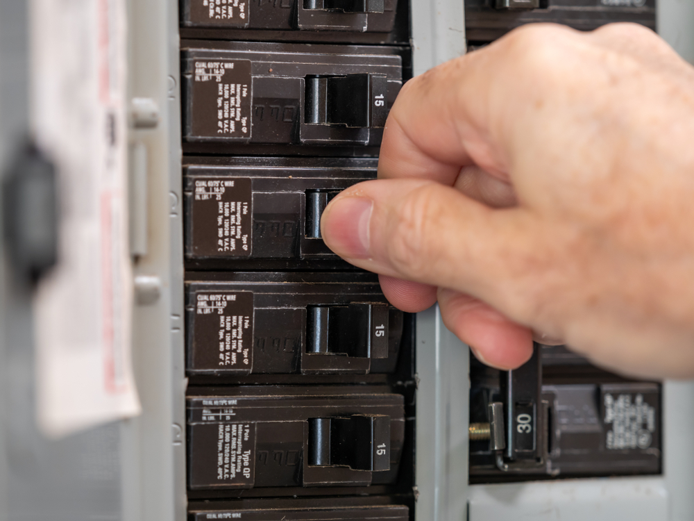 close up of person resetting circuit breaker