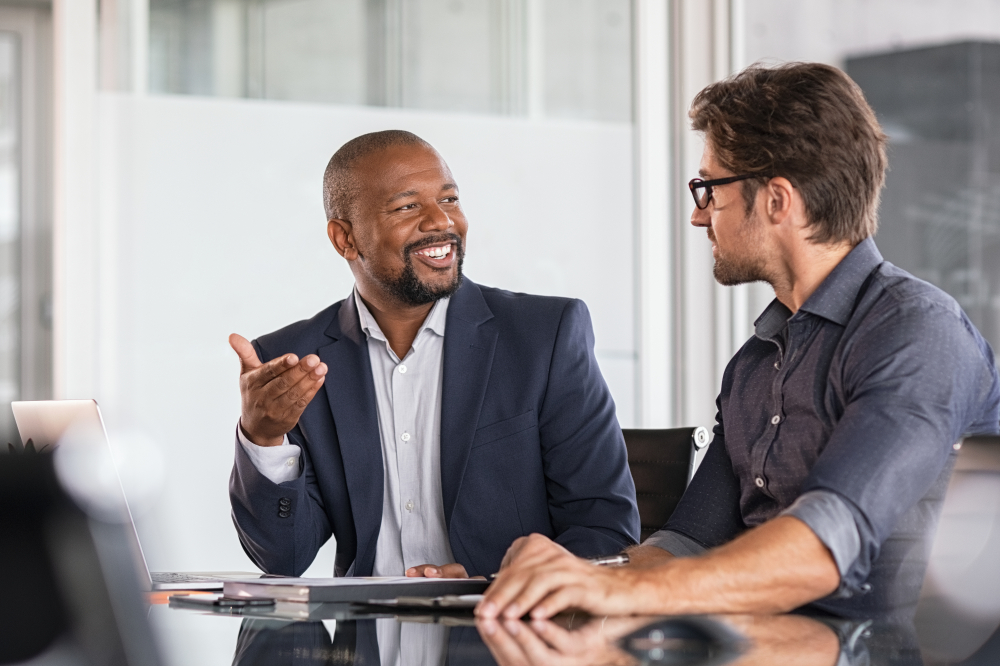 Two people talk at an office table