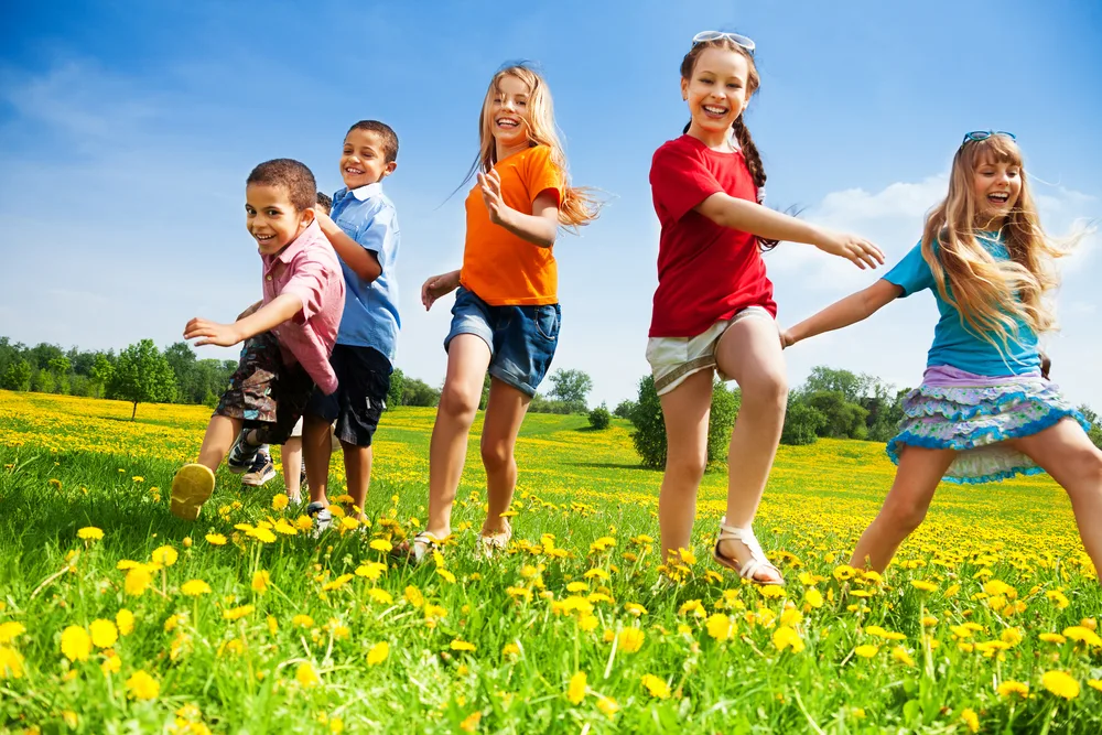 Five happy diversity looking children running in the park
