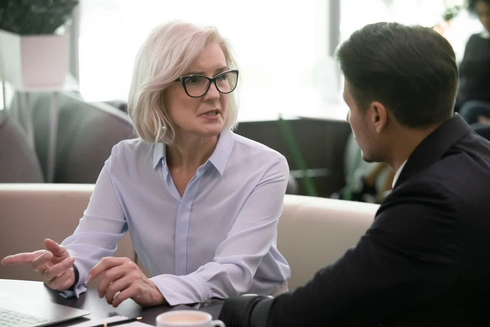 Two people have a conversation on a couch