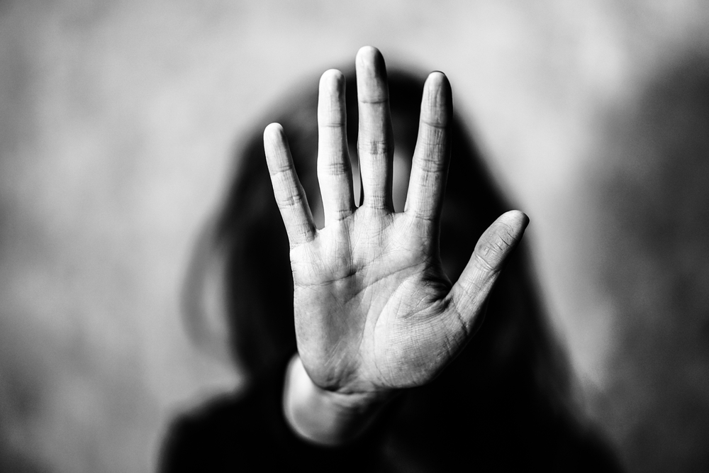 Person holds hand up to the camera with a flat palm to symbolize, "Stop"
