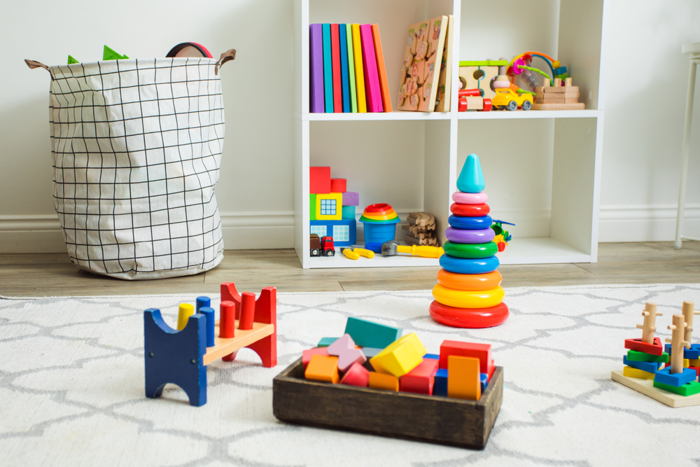 Colorful toys on white carpet in a children’s room. 