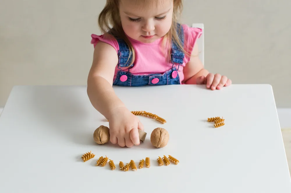 A little girl playing with natural materials. 