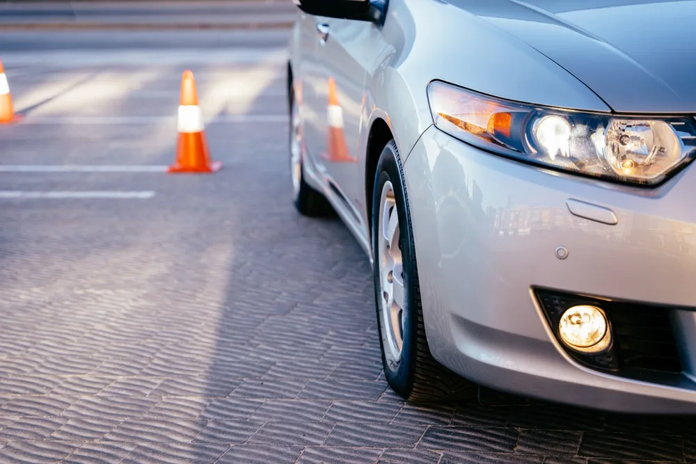 Cones for the examination, driving school concept with a silver car next to the cone