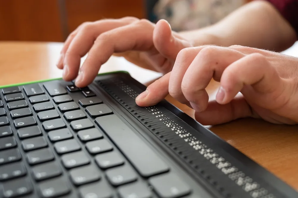 Person using a refreshable braille display.