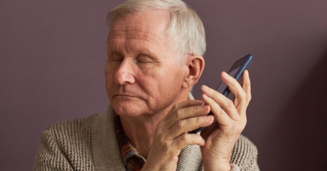 Mature man holding a smartphone near his ear