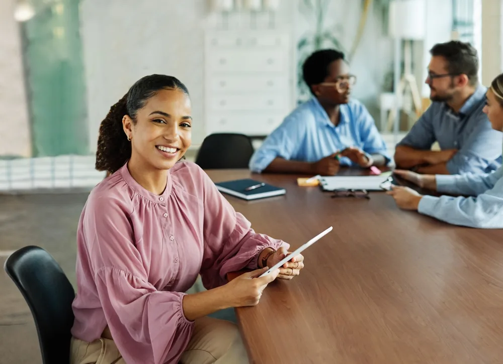 Young mother sitting at a conference table with teachers.
