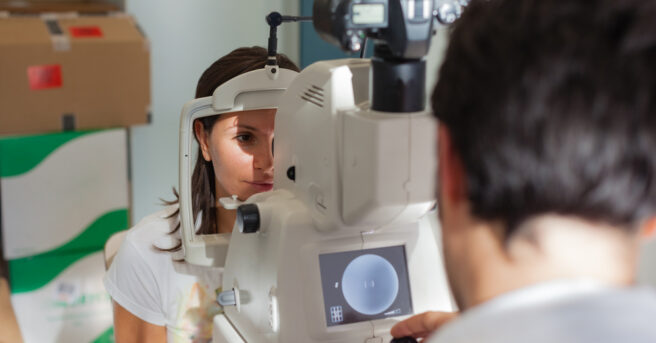 a young ophthalmologist using a non-mydriatic retinal camera on a young girl