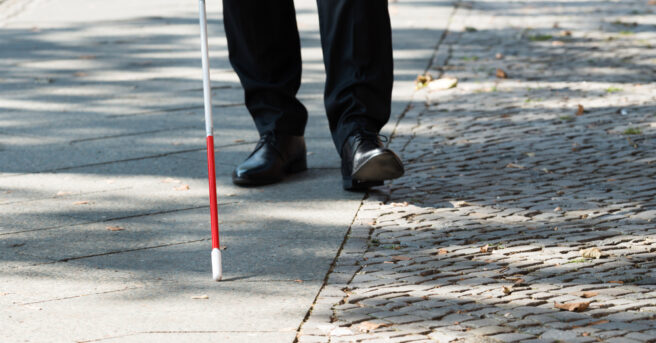 Close-up of person walking with a white cane