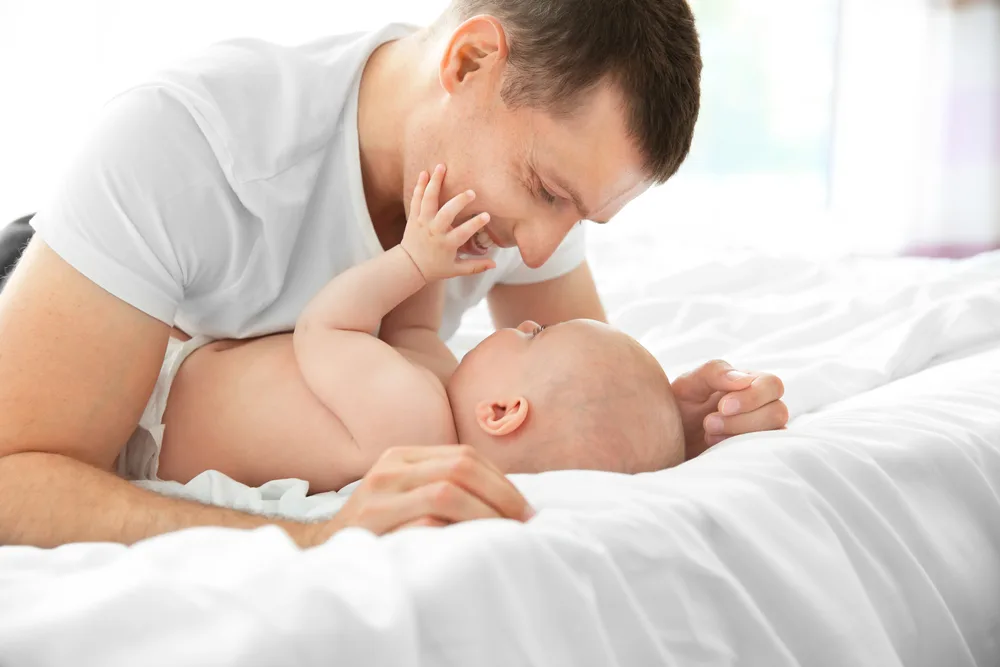 Father with son lying on bed.