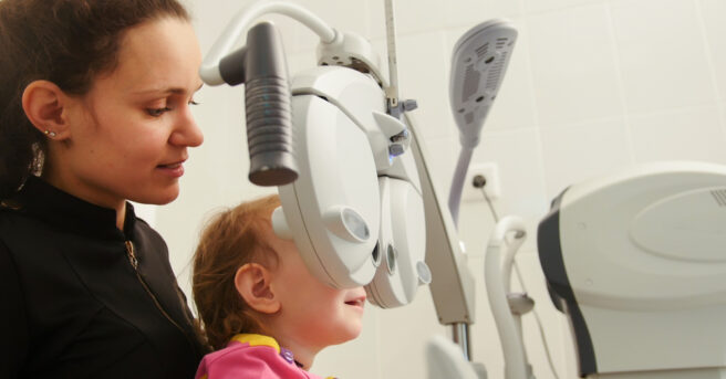 Mother and little girl - optometrist Checks Child's Eye