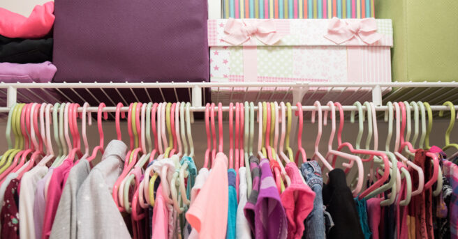 A young girl's closet neatly organized with bins and boxes.