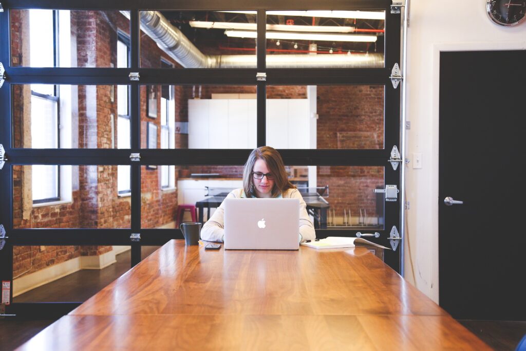 Photo of a woman at the computer in a office board room