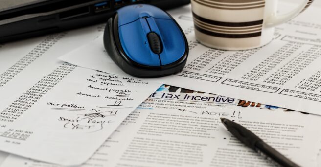 Tax documents and handwritten notes spread across a table