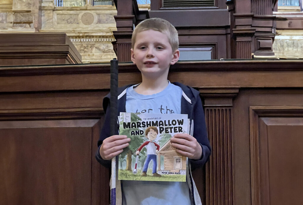 Peter holding the book, "Marshmallow and Peter"