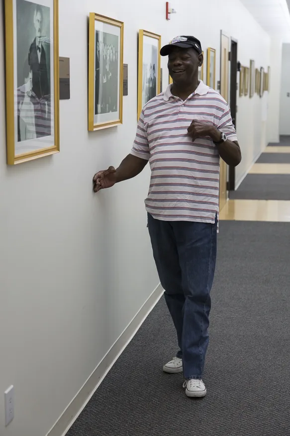 Person trailing a wall--holding their right hand with curled fingers against a wall and proceeding forward