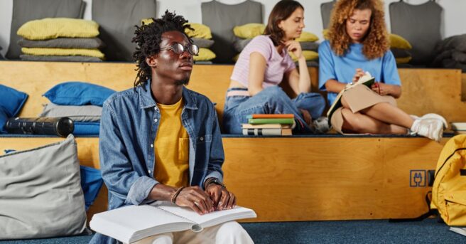 Young adult reading braille