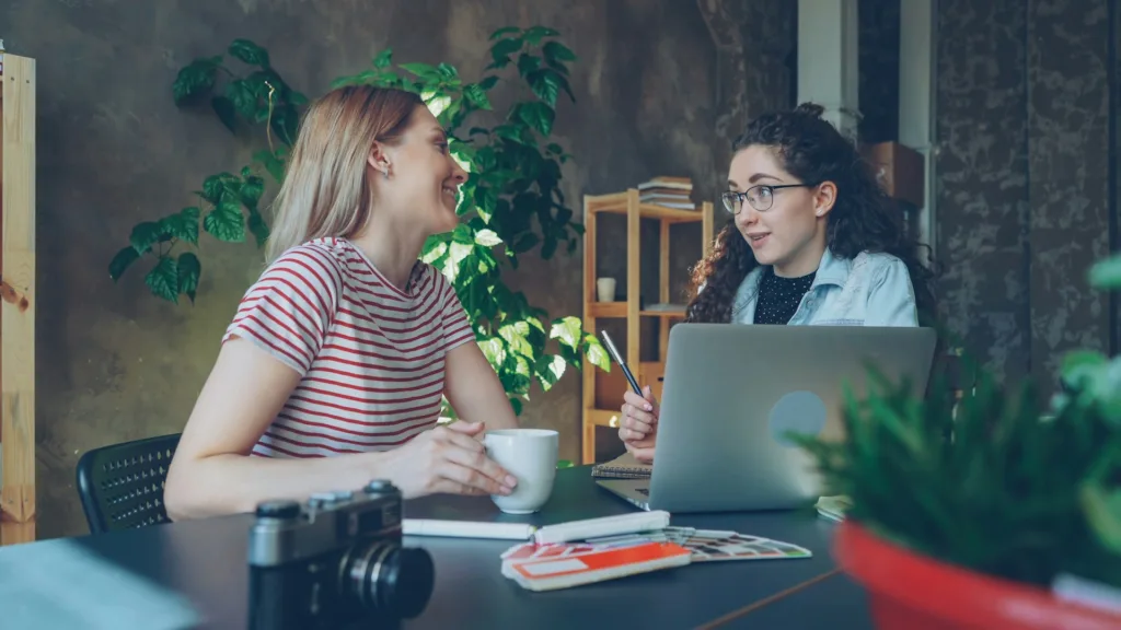 student with eyeglasses talks with a teacher