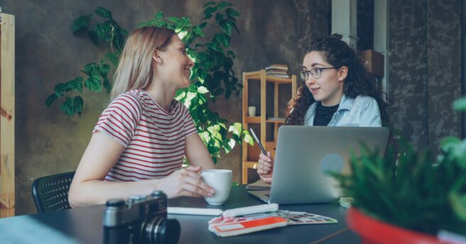 student with eyeglasses talks with a teacher